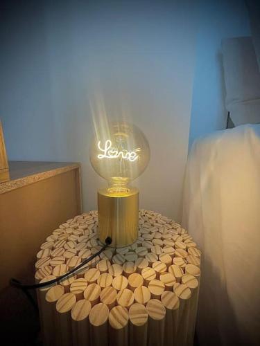 a light on top of a table next to a bed at Le carré d’or mermoz in Marseille