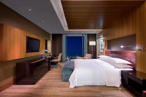 a hotel room with a bed and a desk and a television at Sheraton Grand Bangalore Hotel at Brigade Gateway in Bangalore