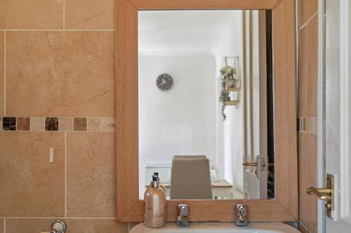 umywalkę w łazience z lustrem nad umywalką w obiekcie 1 bedroom flat Aylesbury, Private Parking, Fowler rd w mieście Buckinghamshire