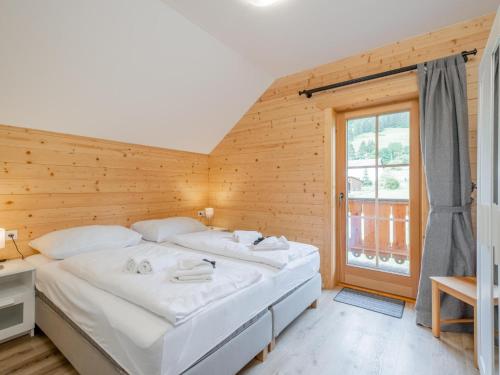sypialnia z dużym łóżkiem i drewnianą ścianą w obiekcie Wolfgangchalet A w mieście Mauterndorf