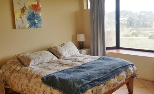 um quarto com uma cama em frente a uma janela em Strandvagen Maitencillo em Maitencillo