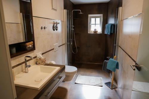 a bathroom with a sink and a shower and a toilet at Ferienwohnung Alter Kuhstall in Neuenstein