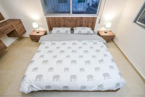 um quarto com uma cama com um cobertor de elefante em Alrabieh, modern 1-bedroom flat em Amã