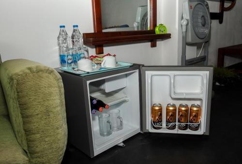 a small refrigerator next to a couch and a table at Shining Green View in Ella