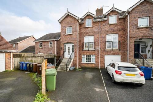 a car parked in front of a brick house at Lovely one bedroom flat. in Belfast