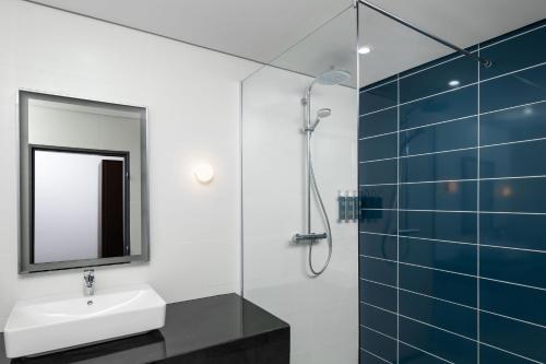 een badkamer met een wastafel en een spiegel bij Four Points by Sheraton Lagos in Lagos
