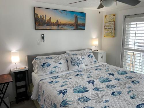 a bedroom with a bed with a blue and white quilt at Bayside Cottage in Clearwater Beach