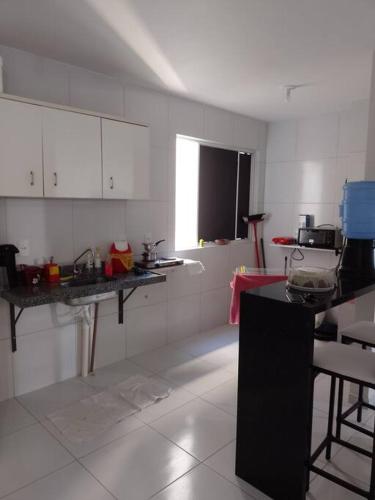 eine Küche mit weißen Wänden und einer schwarzen Arbeitsplatte in der Unterkunft Campina Residence in Campina Grande