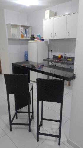una cocina con 2 sillas y una mesa con barra en Campina Residence en Campina Grande