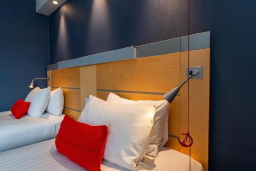 a bedroom with a bed with red and white pillows at Holiday Inn Express Ramsgate – Minster by IHG in Ramsgate