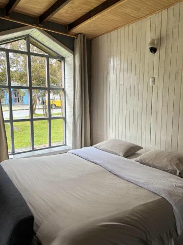 a large bed in a room with a window at QUELEN AUSTRAL in Hornopiren