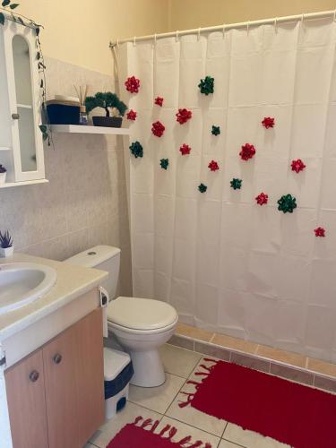 Heiata Lodge Papeete في بابيت: حمام مع مرحاض وستارة دش مع الزهور
