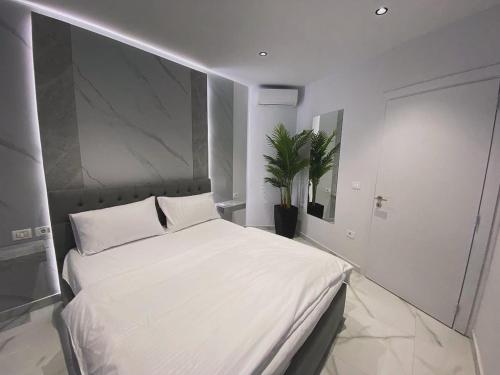 a bedroom with a large white bed in it at Suncity Tirana Luxury Apartments in Selitë e Vogël