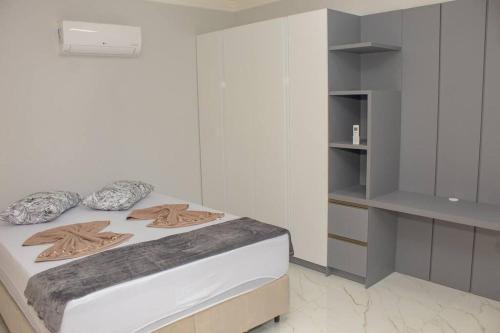 um quarto branco com uma cama e um closet em Apto Novo próximo as Termas e ao Centro de Eventos em Piratuba