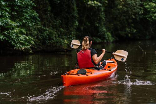 a woman in an orange kayak in the water at Caribbean View in Tortuguero