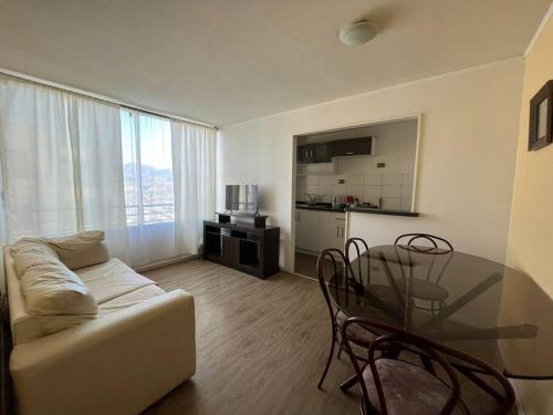a living room with a couch and a glass table at Departamento equipado 322 Ovalle in Ovalle
