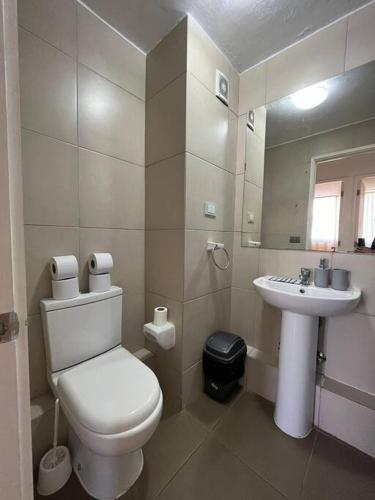 een witte badkamer met een toilet en een wastafel bij Departamento equipado 322 Ovalle in Ovalle