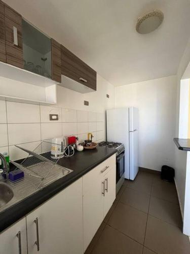 a kitchen with white cabinets and a white refrigerator at Apartamento amoblado 322 Ovalle in Ovalle