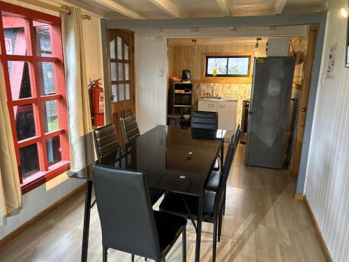 a dining room with a table and chairs and a kitchen at QUELEN AUSTRAL in Hornopiren