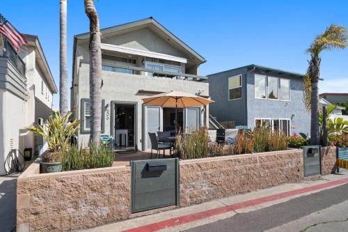 a house with an umbrella on the side of the street at Stunning Beach Home - large patio, parking, ac & dog friendly! in San Diego
