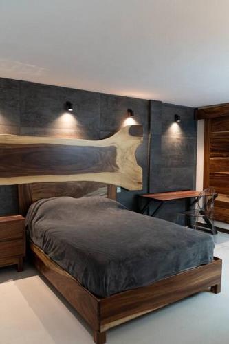 a bedroom with a wooden bed with two lights on it at Árbol de Guanacaste in Zitácuaro