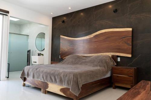 a bedroom with a large wooden bed with a wooden headboard at Árbol de Guanacaste in Zitácuaro