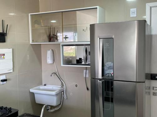 a kitchen with a stainless steel refrigerator and a sink at Ap alto padrão a 50m do sobral shopping in Sobral