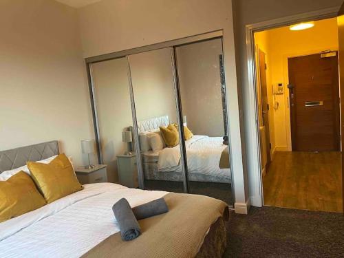 1 dormitorio con cama y espejo grande en Apartment in Central Gillingham en Hoo