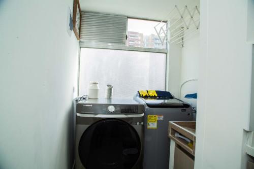 Magnífico Apartamento amoblado Medellín في بيلو: غرفة صغيرة لغسيل الملابس مع غسالة ونافذة