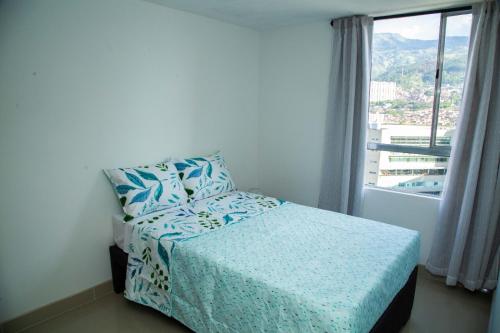 Magnífico Apartamento amoblado Medellín في بيلو: غرفة نوم بسرير ومخدة ونافذة