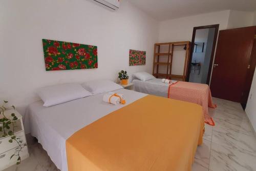um quarto com duas camas e uma mesa em Casa 5km Praia Coroa Vermelha 1 quarto no Térreo em Santa Cruz Cabrália