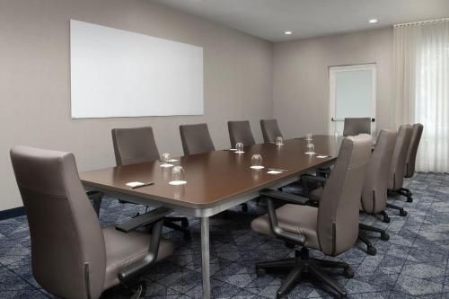 a conference room with a long table and chairs at Courtyard Jacksonville Flagler Center in Jacksonville