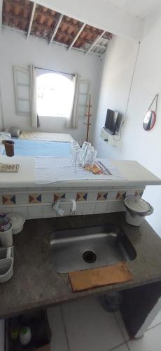 uma cozinha com um lavatório e uma cama num quarto em kitnet praia no Anil Angra dos reis em Angra dos Reis