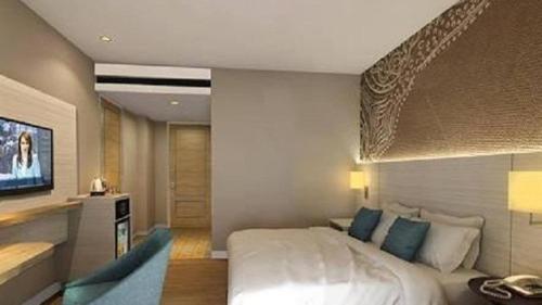 um quarto de hotel com uma cama e uma televisão em Opitalia Catalia Resort em Jakarta