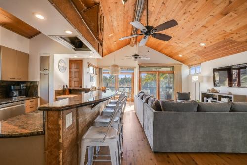 a kitchen and living room with a bar and a ceiling fan at Stunning South Mission Beach Home - AC, Private Patio, Grill and Garage! in San Diego