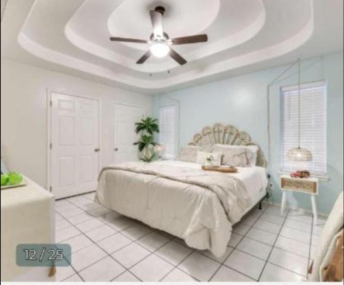 a bedroom with a bed with a ceiling fan at PEBBLES' BEACH HOUSE in Edinburg