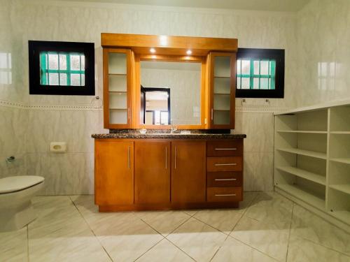 a bathroom with a sink and a toilet and a mirror at CENTRO DE XANGRI-LÁ COM PISCINA in Xangri-lá