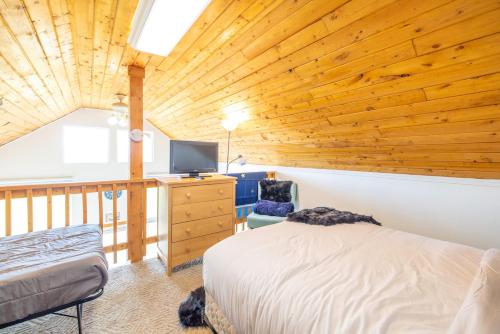 a bedroom with a bed and a television in a room at Lake Vista Chalet - 1BR, Full Kitchen, Wi-Fi in Kenai
