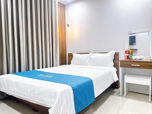 a bedroom with a bed with a blue and white blanket at Milanesa Hotel and Apartment in Vung Tau