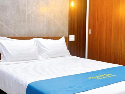 a bed with a blue and white sheets and pillows at Milanesa Hotel and Apartment in Vung Tau
