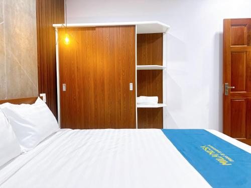 a bedroom with a large bed and a wooden cabinet at Milanesa Hotel and Apartment in Vung Tau