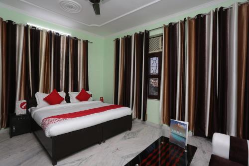 a bedroom with a bed with red pillows at OYO Shree Palce in Ghaziabad