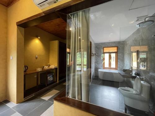 a bathroom with a tub and a sink and a toilet at Sky Bay Lodge in Ha Giang