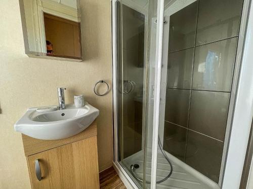 a bathroom with a sink and a shower at Lovely Caravan With Spacious Decking At North Denes In Suffolk, Ref 40134nd in Lowestoft