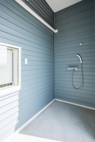 a bathroom with a shower in a blue wall at のと千里浜リゾート in Hakui