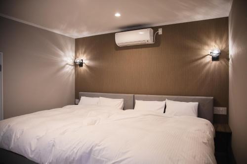 a large white bed in a room with at のと千里浜リゾート in Hakui