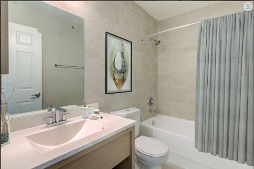 a bathroom with a sink and a toilet and a tub at Cozy Townhouse - Gym Pool Golf Fast WiFi 2B2B in Tampa