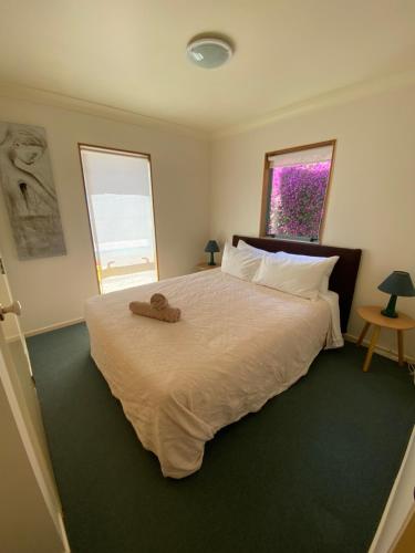 a bedroom with a large bed and a window at Tairua Dream in Tairua