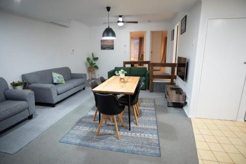 ein Wohnzimmer mit einem Tisch und einem Sofa in der Unterkunft Port Campbell Motor Inn in Port Campbell