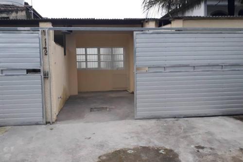 un garage vide avec deux portes de garage devant dans l'établissement Casa a 250 metros a pé da praia. Ótima localização, à Bertioga